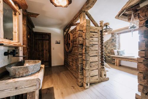 y baño con lavabo de piedra y pared de piedra. en Webertonihütte en Bad Sankt Leonhard im Lavanttal