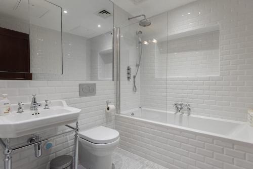 Beautiful Studio On The Strand في لندن: حمام مع مرحاض ومغسلة وحوض استحمام
