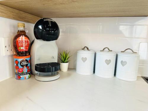 a kitchen counter with a coffee maker and three cups at The Hideaway in Scarborough