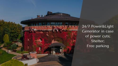 a building covered in red ivy in a garden at Citadel - Gastro Boutique Hotel- Готель Цитадель Львів in Lviv