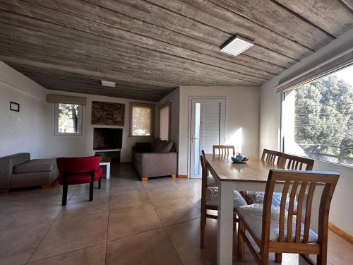 uma sala de estar com um tecto de madeira e uma mesa e cadeiras em Hermoso departamento a estrenar em San Carlos de Bariloche