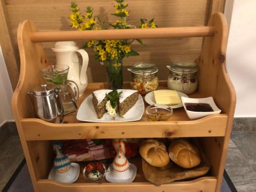 a wooden shelf with a plate of food and bread at Planatschhof in Villnoss