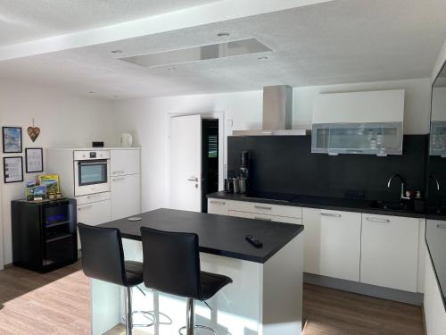 a kitchen with white cabinets and a black counter top at MOUNTAIN HOME apartment in Finkenberg