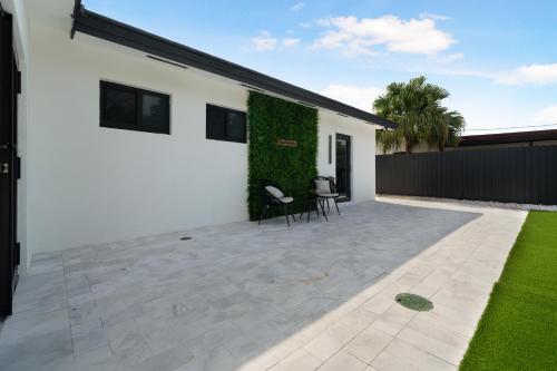 a white house with a patio with a green wall at The lux paradise in Tamiami