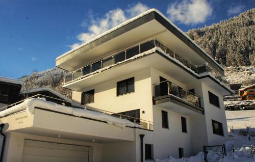 a white apartment building with snow on the ground at MOUNTAIN HOME apartment in Finkenberg