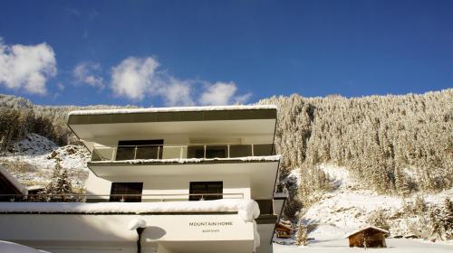 a white building with snow on the ground at MOUNTAIN HOME apartment in Finkenberg