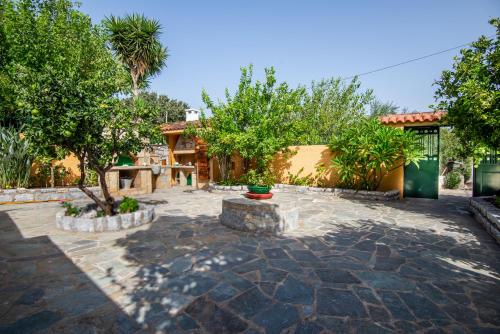 a garden with a patio with trees and a building at VILLA - APA II in Gythio