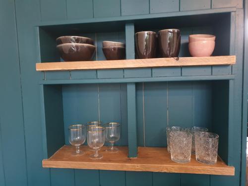 a shelf with glasses and other items on it at Tiny House in de Boomgaard in Stad aan ʼt Haringvliet