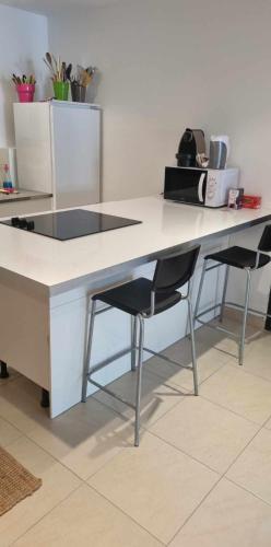 - un bureau blanc avec 2 chaises dans la chambre dans l'établissement Location venelles, à Venelles