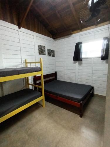 a room with two bunk beds and a window at Chalés Cambury in Camburi