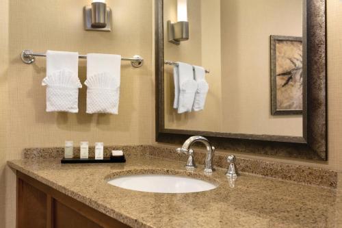 a bathroom with a sink and a mirror and towels at Embassy Suites by Hilton Bloomington/Minneapolis in Bloomington