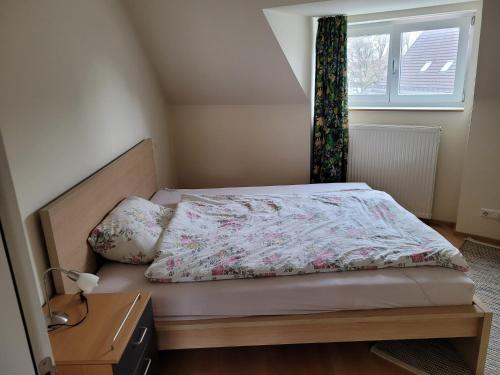 Dormitorio pequeño con cama con edredón de flores en Ferienwohnung Dornbirn City, en Dornbirn