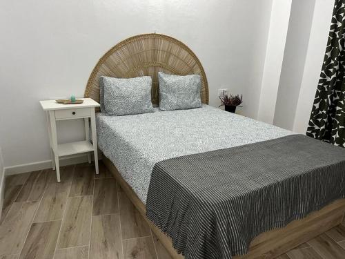 a bedroom with a bed with a night stand and a table at Cueva Lala in Granadilla de Abona