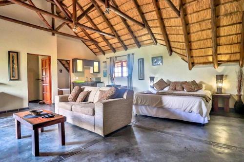 a bedroom with a bed and a couch and a table at Luxury Kruger Escape in Marloth Park