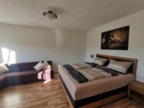 1 dormitorio con 1 cama y 1 sofá en Ferienwohnung mit 3 Schlafzimmern Hartl Hof, en Breitenberg