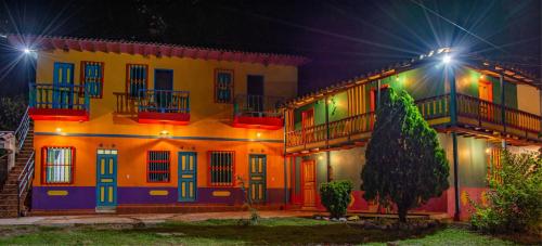 a building with colorful doors and balconies at night at Hosteria Los Alpes de San Roque in San Roque