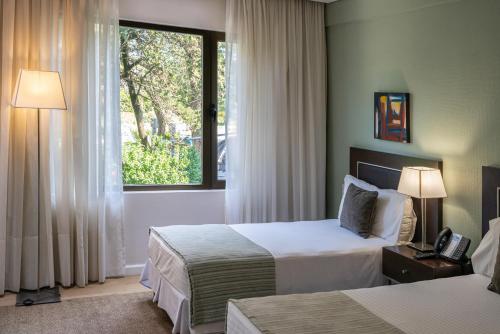 ein Hotelzimmer mit 2 Betten und einem Fenster in der Unterkunft Hotel Uthgra Sasso in Mar del Plata