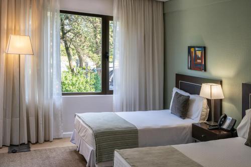a hotel room with two beds and a window at Hotel Uthgra Sasso in Mar del Plata
