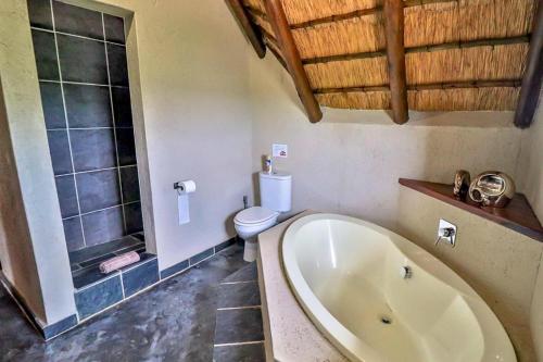 a bathroom with a bath tub and a toilet at Luxury Kruger Escape in Marloth Park