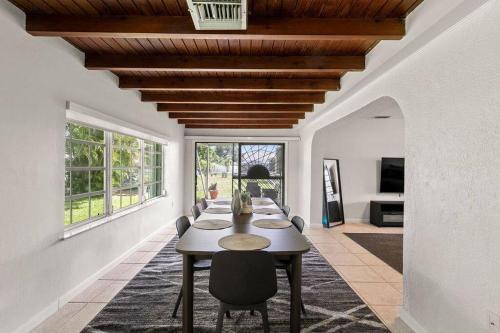 a dining room with a long table and chairs at 3br Oasis near Coral Gable in Miami