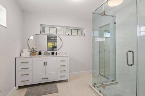 a white bathroom with a mirror and a shower at 3br Oasis near Coral Gable in Miami