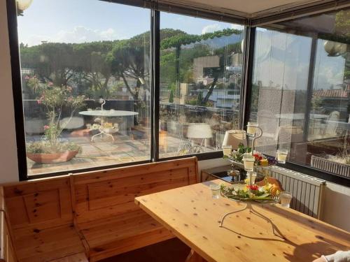 Zimmer mit einem Holztisch und einem großen Fenster in der Unterkunft Attico con vista panoramica! in Montecatini Terme