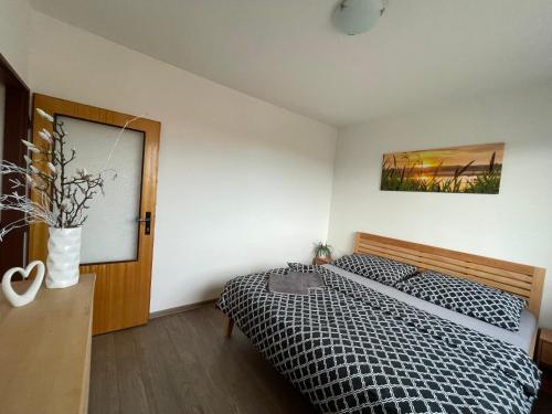 a bedroom with a bed with a black and white comforter at Dětský svět nedaleko Kraví Hory in Bořetice