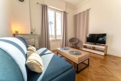 un salon avec un canapé bleu et une télévision dans l'établissement NICE CENTRE-VILLE STUDIO 2 en étage, à Nice