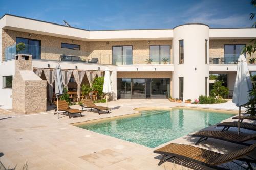 una casa con piscina frente a ella en Villa Elani - Stylish And Modern 6B Seaview Villa en Vrsi