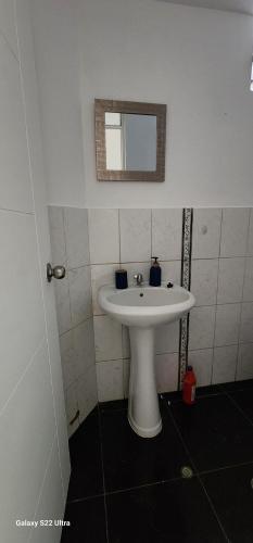 a bathroom with a white sink and a mirror at Céntrico y lindo departamento in Trujillo