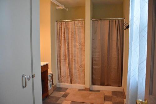 a bathroom with two shower curtains and a sink at The Forgotten City Estate-9BR near Niagara falls in Niagara Falls