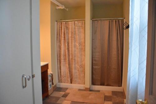 a bathroom with two shower curtains and a sink at Unique Large 9BR House with 3 Bath Close to the falls in Niagara Falls