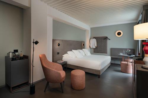 a hotel room with a bed and a chair at VIS Urban Suites&Spa in Bari