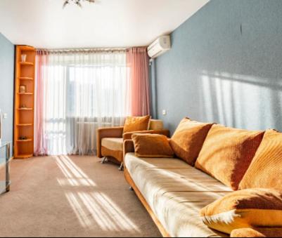 a living room with a couch and a window at Apartment with a panoramic view of Podil near the metro in Kyiv