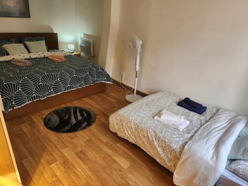 um quarto com uma cama e uma ventoinha de piso em Duplex confortable proche Paris em La Courneuve