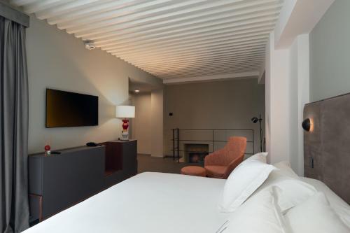a hotel room with a bed and a chair at VIS Urban Suites&Spa in Bari