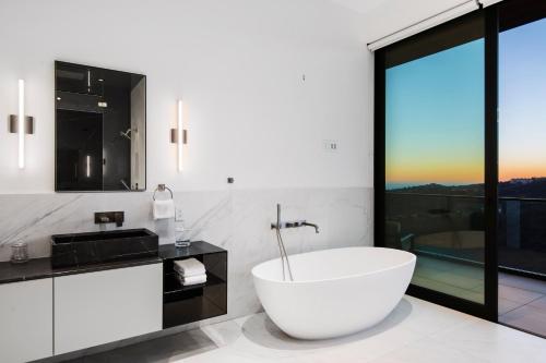 bagno con ampia vasca e lavandino di Linda Flora Modern Estate a Los Angeles