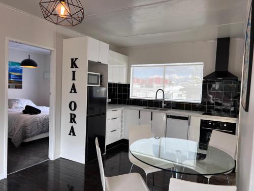 une cuisine avec une table en verre et une cuisine avec un lit dans l'établissement Under Walnut Tree, à Rotorua