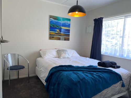 - une chambre avec un lit doté d'une couverture bleue dans l'établissement Under Walnut Tree, à Rotorua