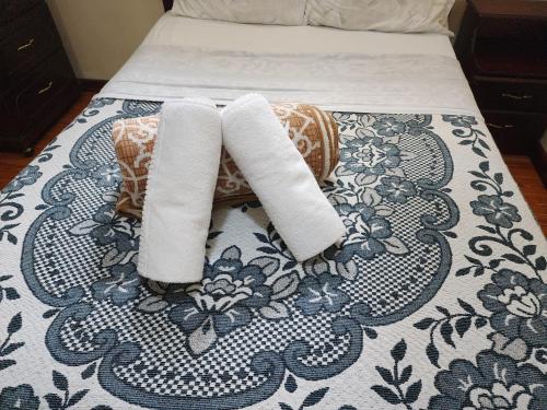 a bed with two rolled towels on top of it at Hotel Casa Franciscana in Quito