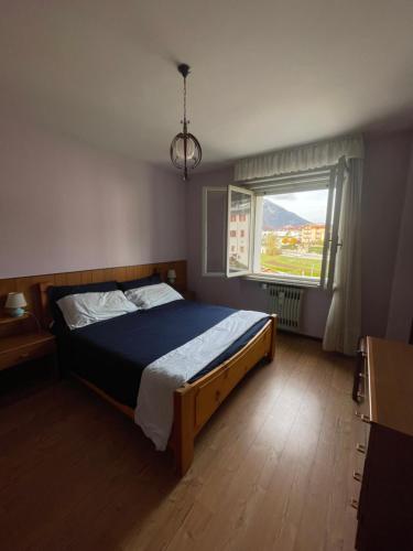 - une chambre avec un lit et une grande fenêtre dans l'établissement Casa Anna - Andalo centrale sugli impianti da sci, à Andalo
