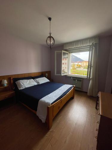 a bedroom with a bed and a large window at Casa Anna - Andalo centrale sugli impianti da sci in Andalo