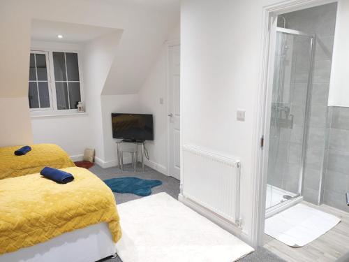 1 dormitorio con cama amarilla y TV en Cosy Family Home in Long Eaton, Nottingham en Nottingham