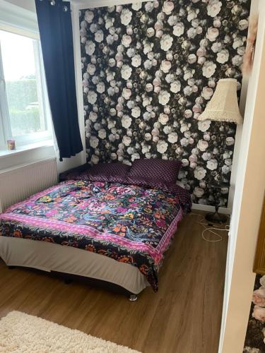 a bedroom with a bed with a floral wallpaper at Apartament Calineczka in Reda