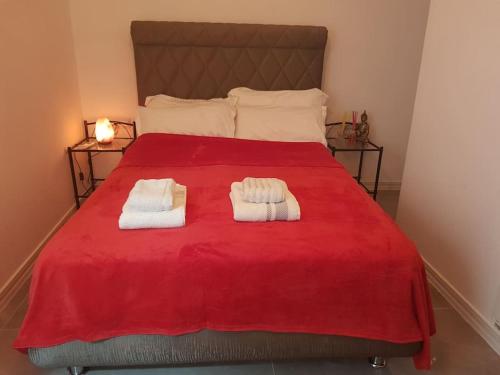 1 dormitorio con 1 cama roja y 2 toallas en Mar y Sol Suites, en Grao de Castellón