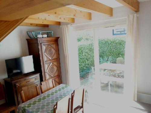 a dining room with a table and chairs and a window at Appartement type chalet 2 chambres avec terrasse in Cauterets
