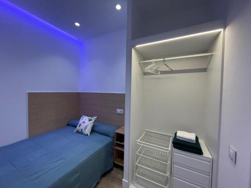 a bedroom with a blue bed and a closet at Cozy apartment in Plaza España /Gran Vía in Madrid