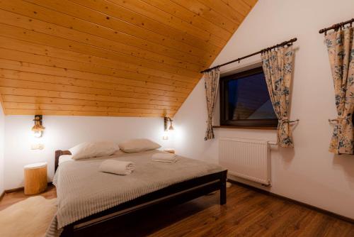 1 dormitorio con cama y techo de madera en Domki Pod Wulkanem, en Krośnica