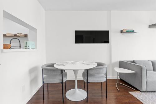 a white room with a table and chairs and a couch at Downtown Luxury 1BR Coal Harbour in Vancouver