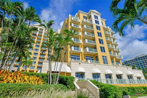 a large yellow building with palm trees in front of it at Stylish Suite to Have a Great Stay! in Miami